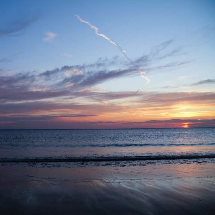 日没時に岸に打ち寄せる海の波 スライディングパズル・オンライン