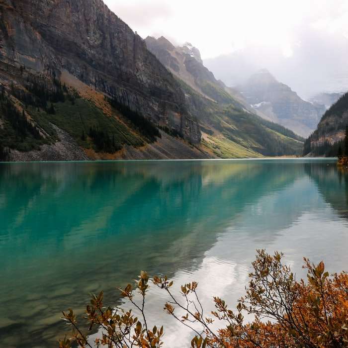 lago rodeado de montañas durante el día. puzzle deslizante online