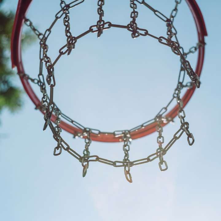 φωτογραφία χαμηλής γωνίας του κόκκινου στεφάνου μπάσκετ κάτω από το γαλάζιο του ουρανού online παζλ