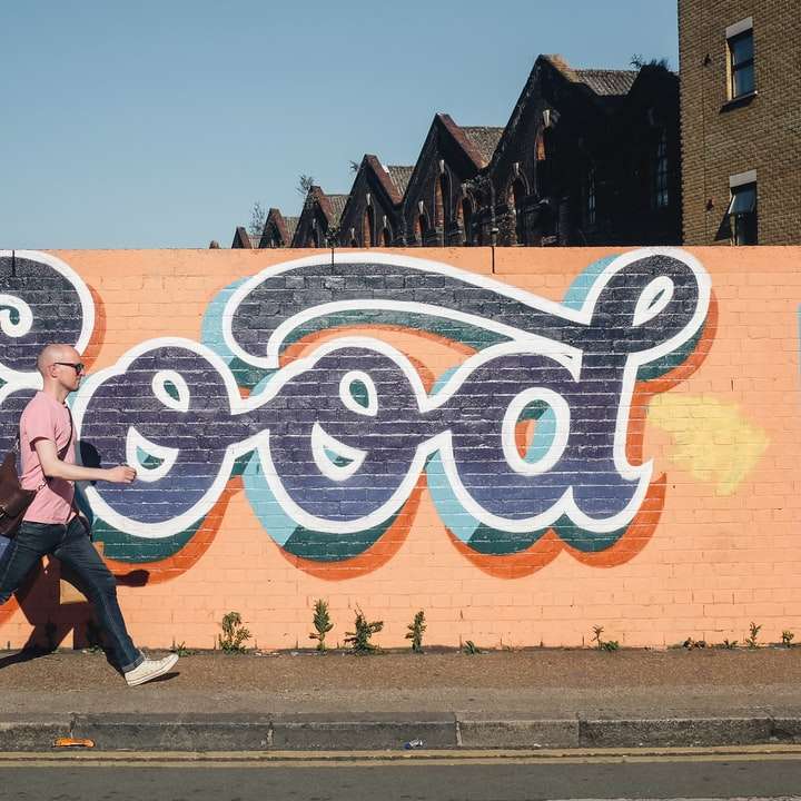 άνδρας που περπατά δίπλα στον τοίχο γκράφιτι συρόμενο παζλ online