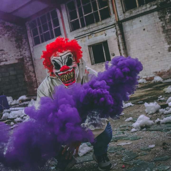clown som håller en lila rökbomb i en förstörd byggnad glidande pussel online