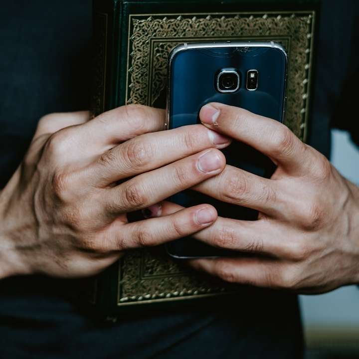 osoba držící černý a šedý smartphone online puzzle