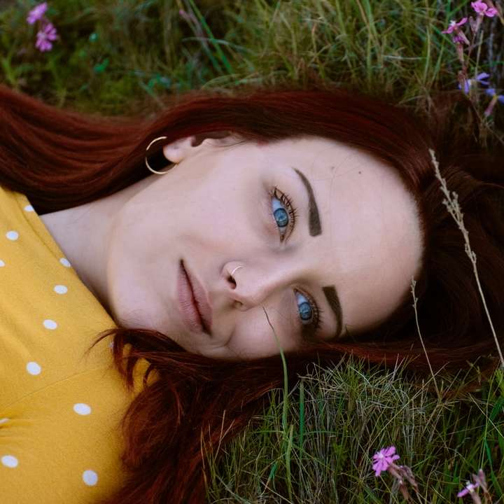 woman in brown and white polka-dot top lying in green grass online puzzle