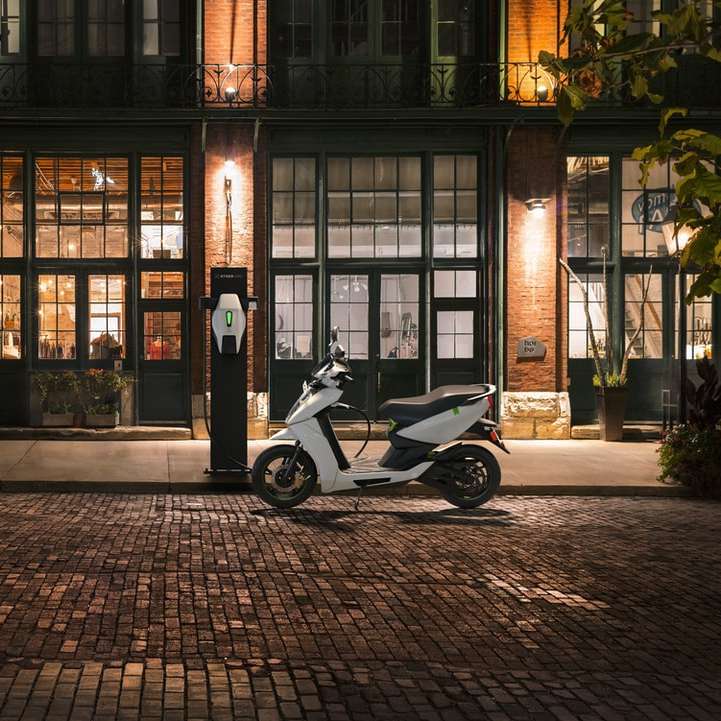 чорно-білий скутер, припаркований біля коричневої будівлі онлайн пазл
