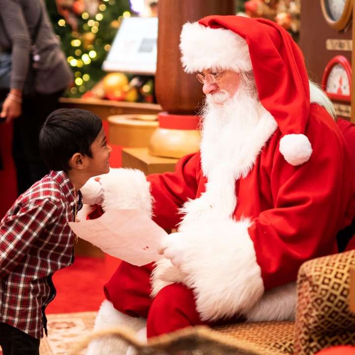 băiat care stă în fața unui bărbat îmbrăcat în costum de Moș Crăciun puzzle online
