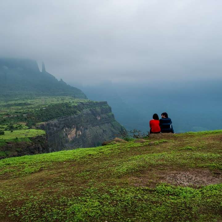 persoon zittend op groen grasveld tijdens mistige dag schuifpuzzel online