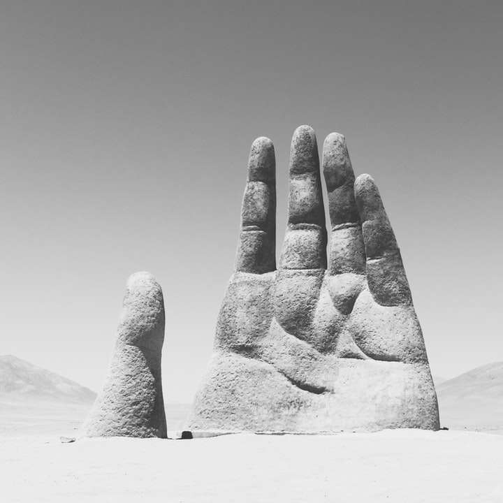 fotografía en escala de grises de la escultura de la mano en triste puzzle deslizante online