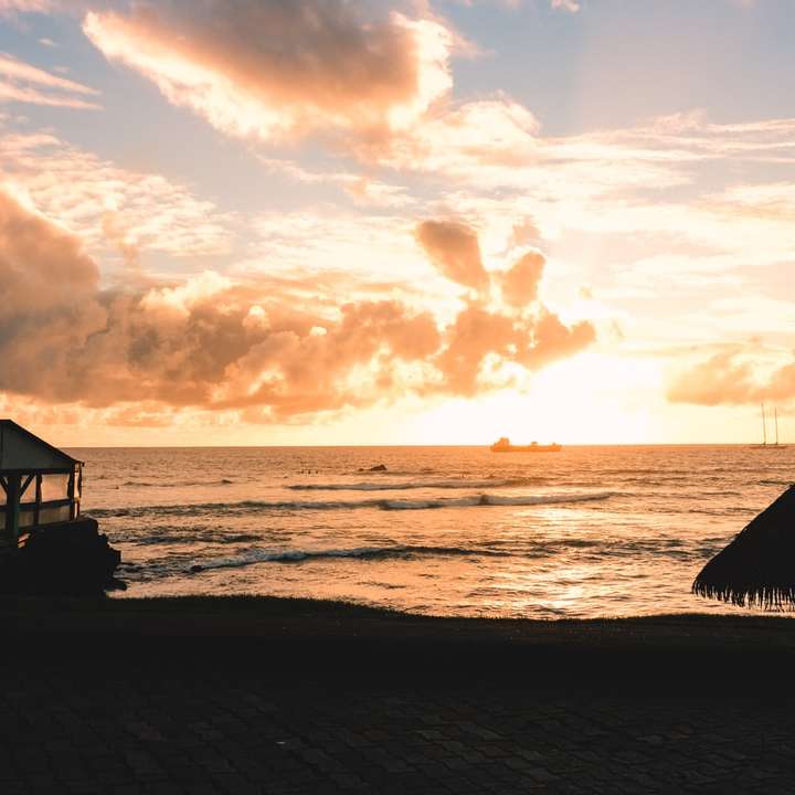 silhueta de pessoas na praia durante o pôr do sol puzzle deslizante online